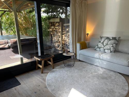 a living room with a couch and a large window at B&B Sonnegaerde in Arnhem