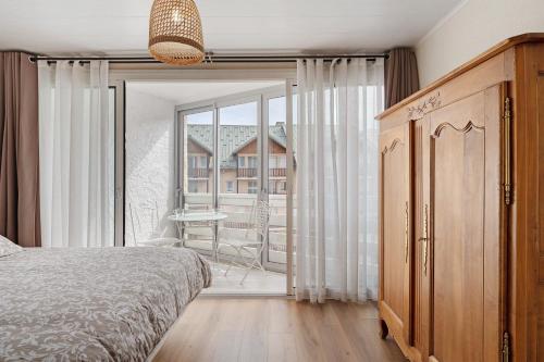 a bedroom with a bed and a large window at Les Gemeaux 2 - 6 personnes in Villard-de-Lans