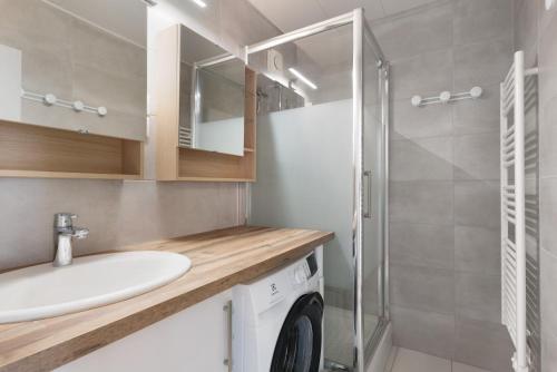 a bathroom with a sink and a washing machine at Les Gemeaux 2 - 6 personnes in Villard-de-Lans