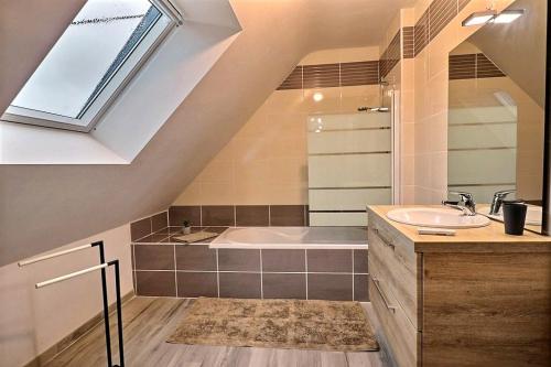 un bagno con lavandino e vasca da bagno di De la grée a Cruguel