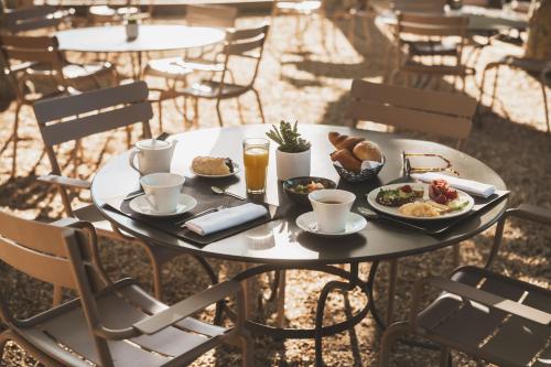 a table with plates of food and drinks on it at Les Lodges Sainte-Victoire Hotel & Spa in Aix-en-Provence