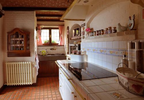 a kitchen with a sink and a stove top oven at Insolites à Chimay - Les roulottes à Rièzes in Chimay