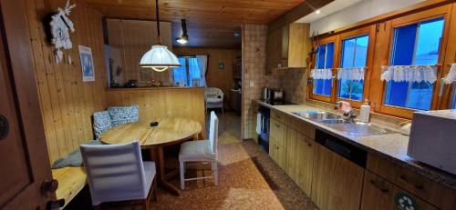 a kitchen with a table and chairs in a cabin at Chalet Ferreira in Weite