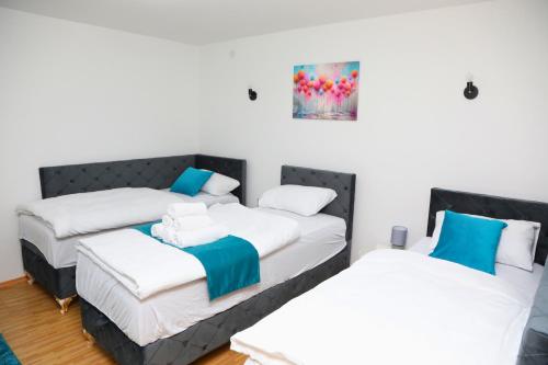 two beds in a room with white and blue at City Apartman 101 in Bosanski Brod