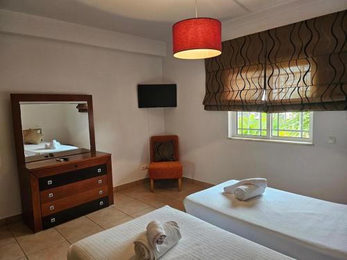 a bedroom with two beds and a sink and a mirror at Vila das Pétalas in Portimão