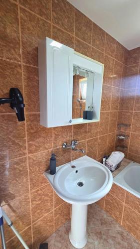 a bathroom with a white sink and a mirror at City Apartman 101 in Bosanski Brod