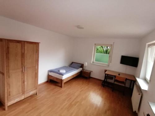 a bedroom with a bed and a desk in a room at Ferienwohnung Haus Lohne in Lohne