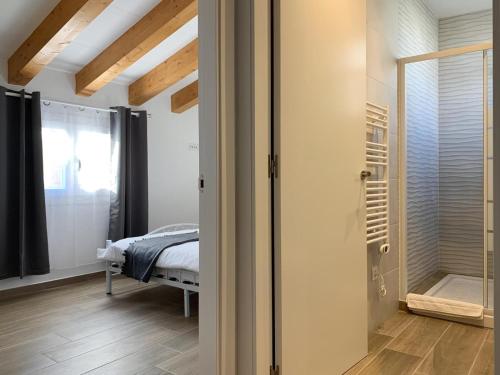 a bedroom with a bed and a walk in shower at Homenfun Vila Badalona in Badalona