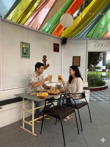 a man and woman sitting at a table with drinks at Gauri Resort in Pune