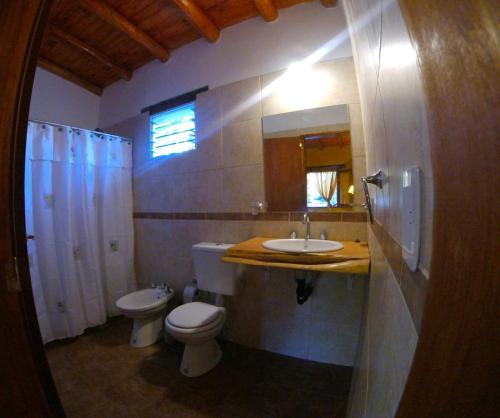 a bathroom with a sink and a toilet and a mirror at Aypa Pacha Nono in Nono