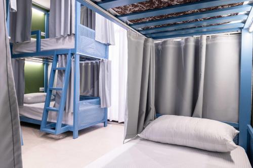 sypialnia z dwoma łóżkami piętrowymi i drabinką w obiekcie Mega Hostel w Sarandzie