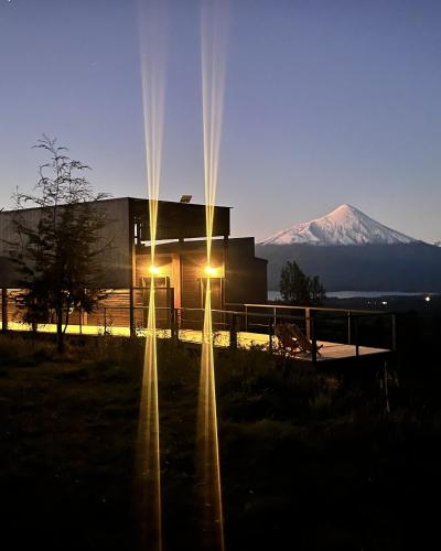 a building with lights in front of a mountain at Ampe Lodge in Puerto Varas