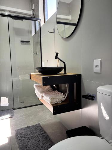 a bathroom with a sink and a mirror and a toilet at Residencial Zoe 102 in Foz do Iguaçu