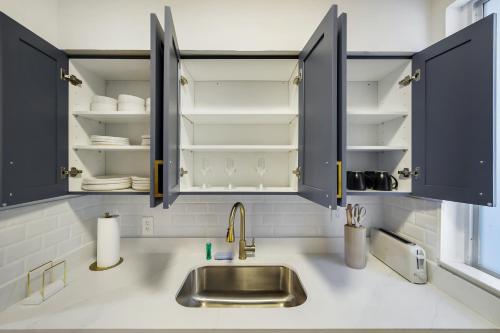 a kitchen counter with a sink and open cabinets at 8040 Harding Apts in Miami Beach