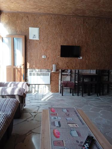 a living room with a couch and a tv on a wall at -DO- Gradac in Šavnik