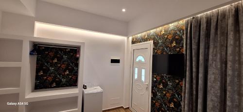 a hallway with a painting on the wall next to a door at Cozy White House - Near Beach Private Jacuzzi in Ksamil