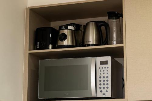 a cabinet with a microwave in a kitchen at Steps from the Shopping del Sol! in Asunción