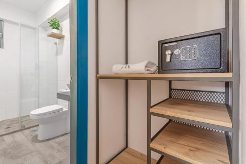 ein Badezimmer mit Toilette und einem Fernseher auf einem Regal in der Unterkunft LA RAMBLA Hotel Boutique - Cusco in Cusco