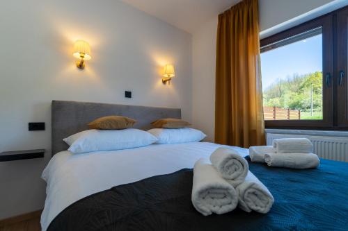 a bedroom with a large bed with towels on it at Silentium Apartment in Donji Prozor