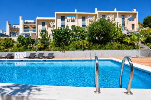 a swimming pool in front of a building at Exquisite Costa Blanca Escape Townhouses in El Campello