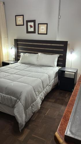a bedroom with a large bed and two tables at No7 Mc Intyre Guest House in Sasolburg
