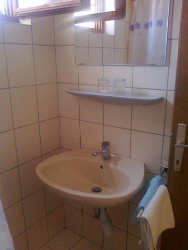 a white bathroom with a sink and a mirror at Penzion Sovulj SKALLA CZ in Omiš