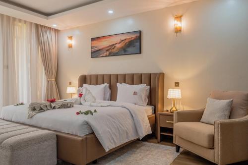 a bedroom with a large bed and two chairs at WOODSY Resort in Nanyuki