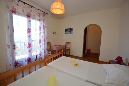 a bedroom with a white bed and a window at Penzion Sovulj SKALLA CZ in Omiš