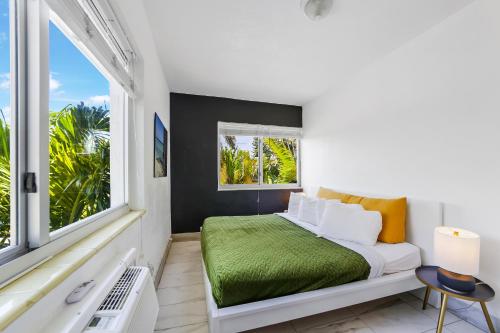 a white bedroom with a bed and a window at 8040 Harding Apts in Miami Beach
