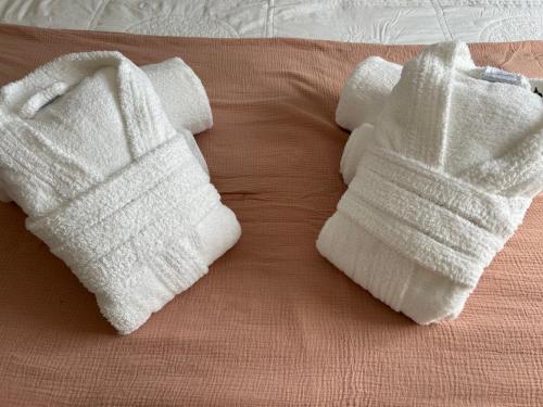 two white towels sitting on top of a bed at Résidence Alba in Bonifacio