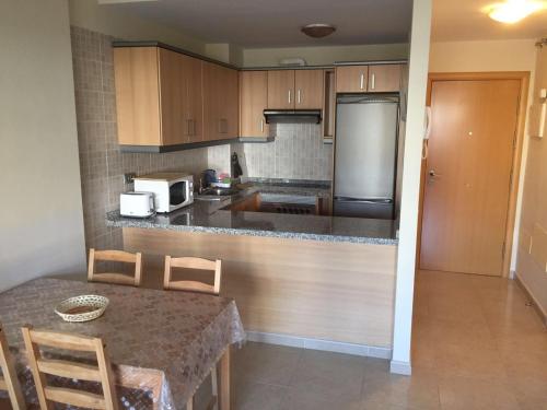 a kitchen with wooden cabinets and a table with chairs at Apartamentos EOS in Buzanada