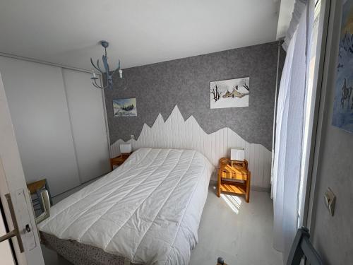 a bedroom with a white bed and a wall with a shark pattern at Appartement 4 personnes avec terrasse Centre ville in Cauterets