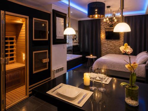 a room with a bed and a table with wine glasses at Appart' Spa et Sauna Privatif Au Cœur De Beaune in Beaune