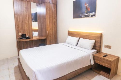 a small bedroom with a bed and a mirror at El Bakatir in Banyuwangi