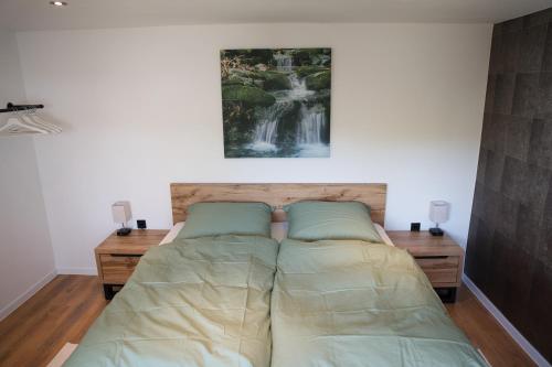 a bed in a bedroom with a painting on the wall at Ferienwohnung Mangfalltal in Bruckmühl