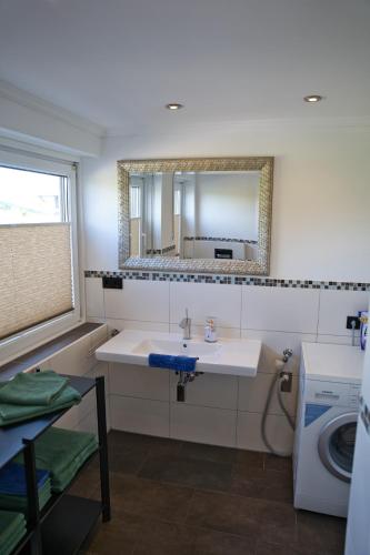 a bathroom with a sink and a mirror at Ferienwohnung Mangfalltal in Bruckmühl