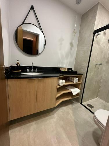 a bathroom with a sink and a mirror at Flat Portal Premium Vinhedo in Vinhedo