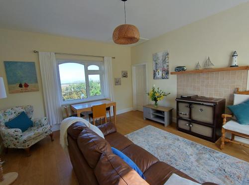 a living room with a couch and a table and a window at Kates coastal cottage in Aillemore
