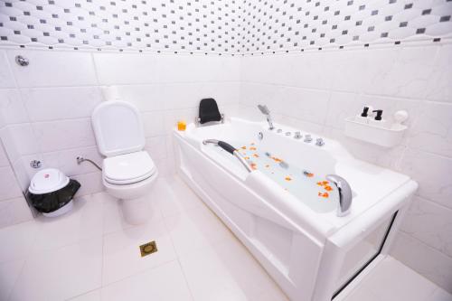 a white bathroom with a tub and a toilet at Villa d'exception - Piscine à débordement - Vue sur la mer - Barbecue - Salle de sport - Jusqu'à 12 personnes in Feddane Chappo