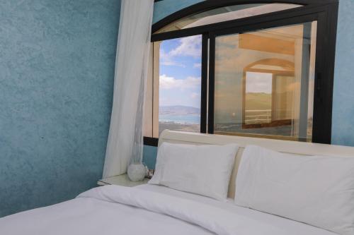 a bedroom with a bed with a large window at Villa d'exception - Piscine à débordement - Vue sur la mer - Barbecue - Salle de sport - Jusqu'à 12 personnes in Feddane Chappo