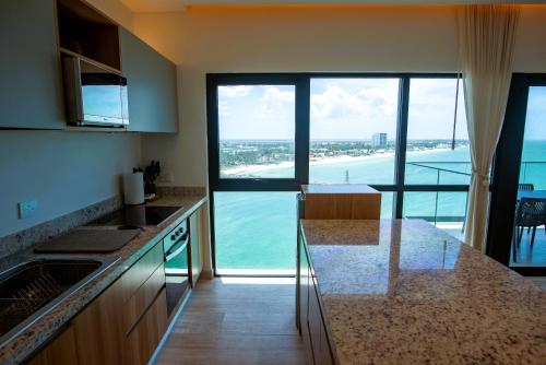 a kitchen with a view of the ocean at Ocean's Embrace and unforgetful sunsets in Progreso