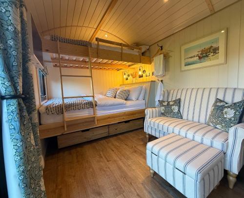 a room with two beds and two couches in a rv at Orchard House Holiday in Bungay