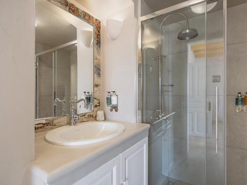a bathroom with a sink and a glass shower at Bellevalia Hydra in Hydra