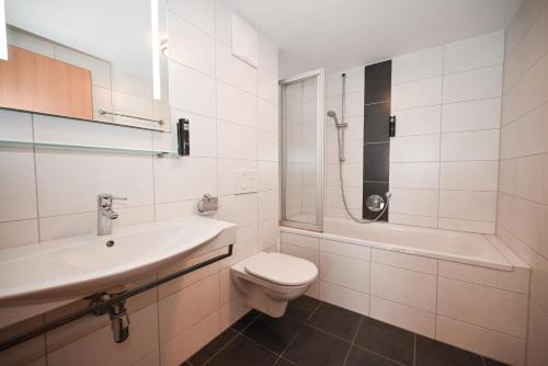a bathroom with a toilet and a sink and a shower at Appartementhaus Kristall incl Joker Card by All in One Apartments in Saalbach-Hinterglemm