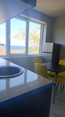 a room with a table and chairs and windows at ВЕСЕЛА ВАКАНЦИЯ Китен in Kiten
