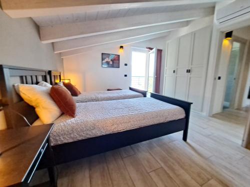 a bedroom with two beds and a table in it at Immobillario - Casa Luna in Domaso