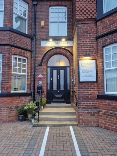 an entrance to a brick building with a black door at Crescent Lodge Guest House in Whitby