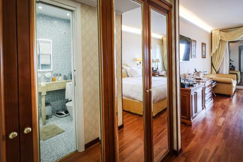 a bedroom with a bed and a bathroom with a mirror at Grand Hotel Del Mare Resort & Spa in Bordighera