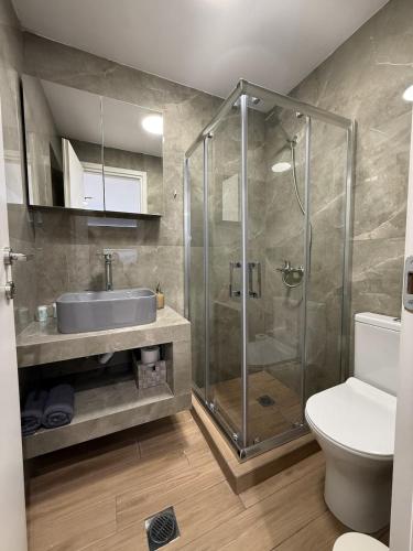 a bathroom with a shower and a sink and a toilet at Archanes Cozy Retreat in Archanes