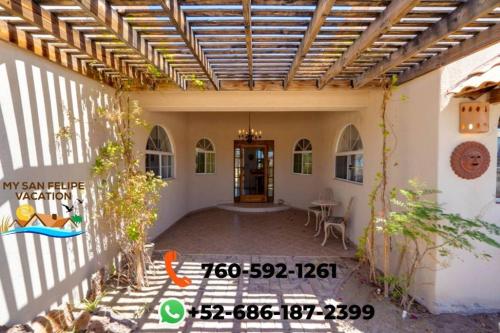 a patio of a house with a wooden pergola at Mountain side Delight - Palapas house San Felipe Vacation Rental in San Felipe